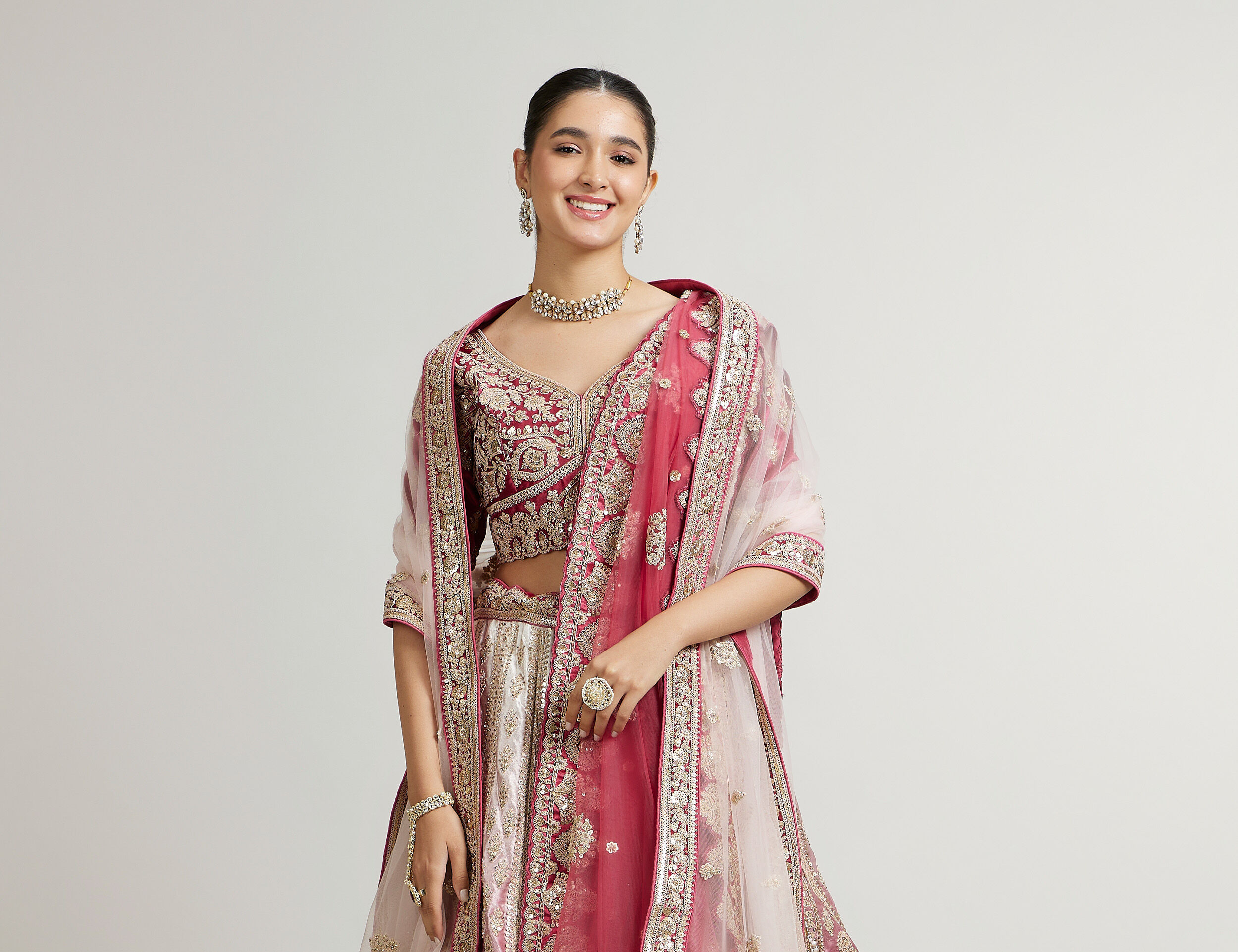 A beautiful bride wearing a pink lehenga with elegant wedding jewellery